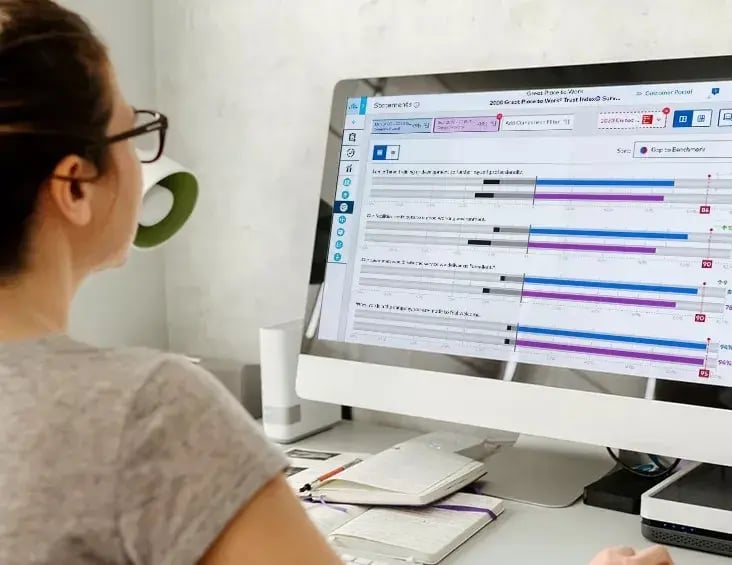 Personne de dos devant un ordinateur montrant des statistiques