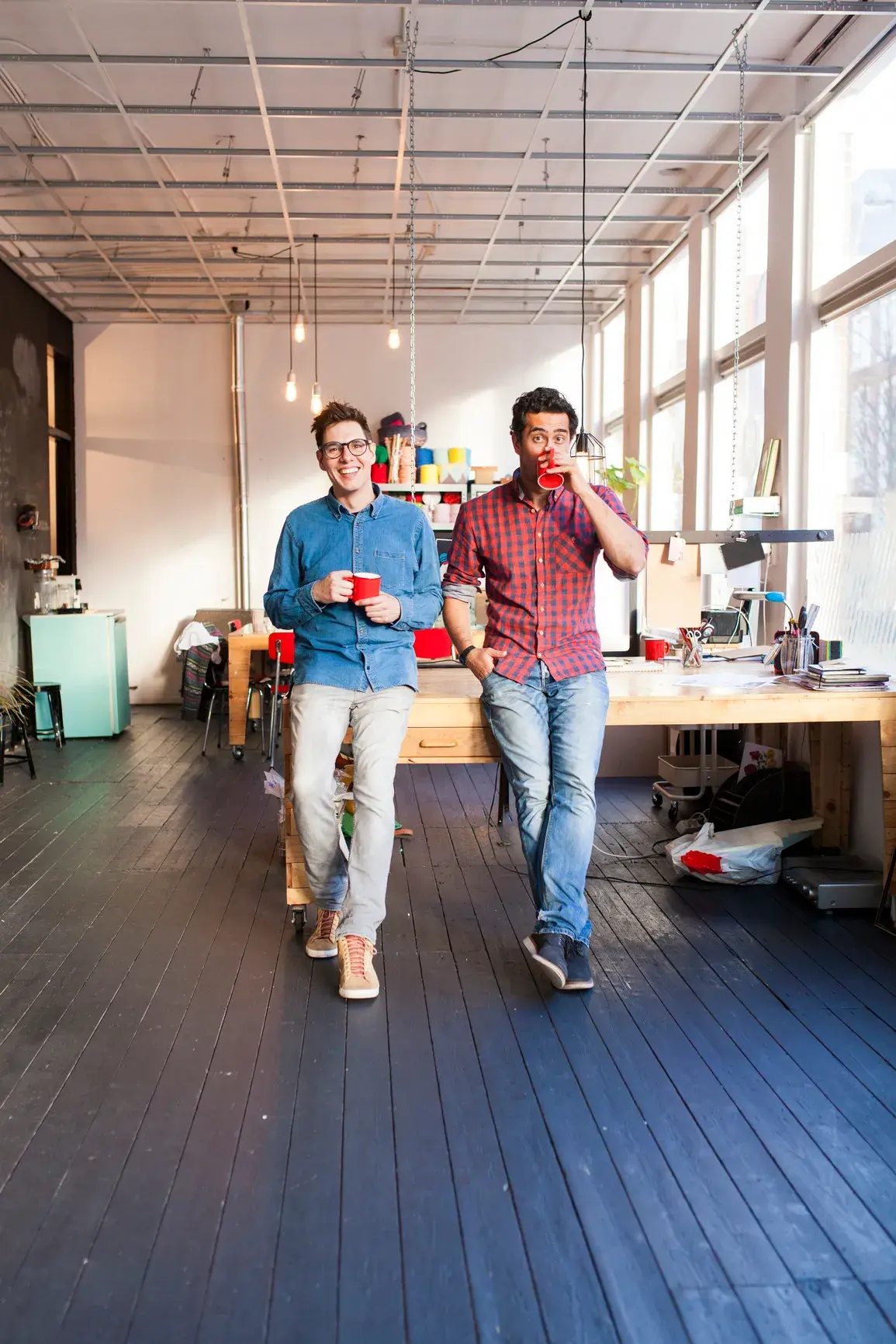 2 hommes appuyés sur un bureau