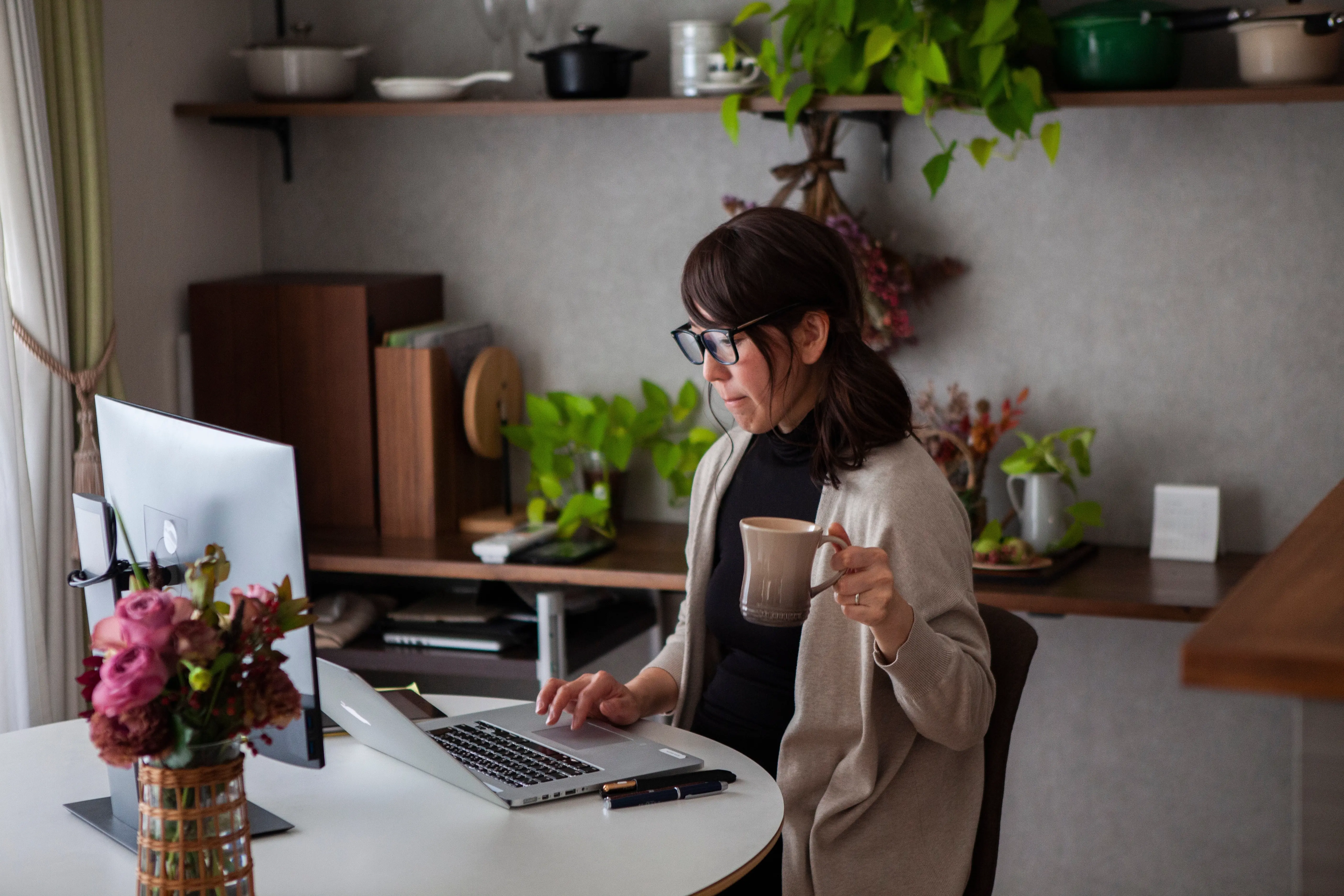Femme tenant une tasse travaillant a la maison